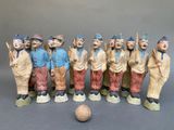 many figurines of asian men standing next to a ball