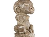an image of a statue of a monkey sitting on top of a rock
