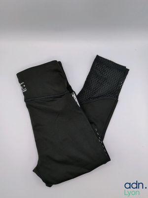 un gros plan sur une paire de leggings noirs posés sur une surface blanche