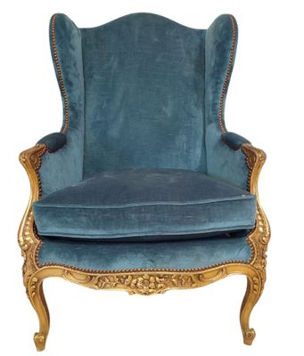 une chaise bleue avec une structure dorée et recouverte de velours bleu