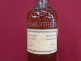 an old bottle of whisky sits on a red surface