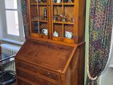 un meuble en bois avec une porte en verre dans une pièce