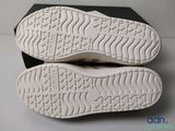 the soles of a pair of white shoes are on a black box