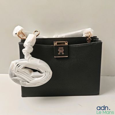 un sac à main noir auquel est attaché un cordon blanc