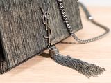 a black purse with a tassel hanging from it
