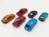 several toy cars are lined up in a row on a white surface