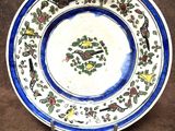 une assiette bleue et blanche décorée d'oiseaux et de fleurs
