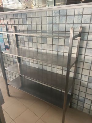 une étagère métallique posée au sol devant un mur carrelé