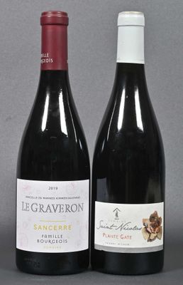 two bottles of wine sitting next to each other on a table