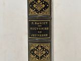 un livre noir et or posé sur une table blanche