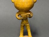 yellow ceramic figurine of a man with horns on his head
