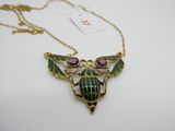 un collier vert et doré orné d'un scarabée