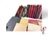 many books that are stacked together on a table