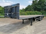 une remorque à plateau garée sur le bord de la route