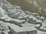 a black and white photo of a village in the mountains