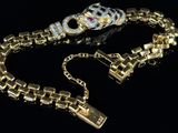 a close up of a gold bracelet with a skull on it