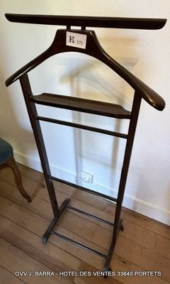 un porte-manteau muni d'un cintre, placé dans un coin de la pièce