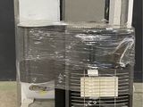 une pile d'appareils électroménagers posée sur une palette devant un mur noir
