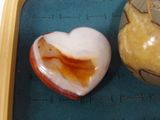 a heart shaped stone next to a jar of honey