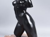 a black sculpture of a woman on a marble base