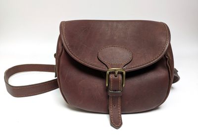 un sac à bandoulière en cuir marron muni d'une boucle métallique