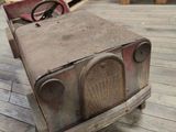 an old fashioned toy car sitting on a wooden floor