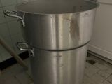 a large metal pot sitting on the floor in the kitchen