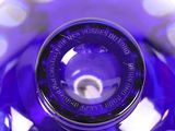 a purple glass vase with a black top and a white base
