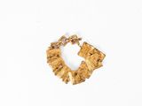 Le bracelet en or est fabriqué à partir d'un morceau de bois et comporte une chaîne qui y est attachée.