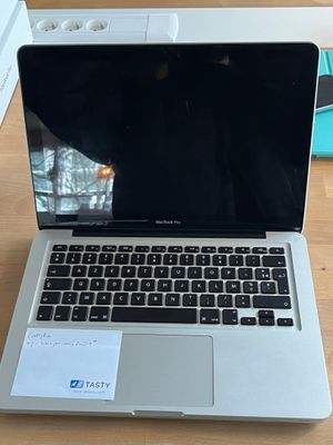 a laptop computer sitting on a table with a notepad