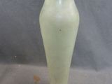 a white vase with a yellow top sitting on a table