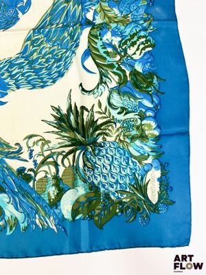 une photo d'une écharpe bleue et blanche ornée de paons