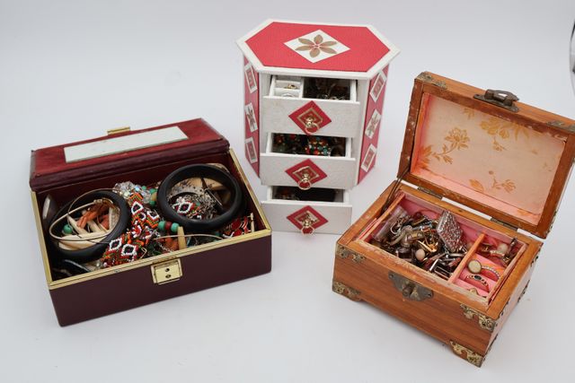 Trois coffrets garnis de bijoux fantaisie, un marqueté, un en cui...