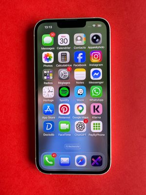 un gros plan d'un téléphone portable posé sur une surface rouge