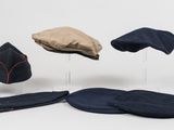 several hats and mitts are sitting on a stand on a white surface