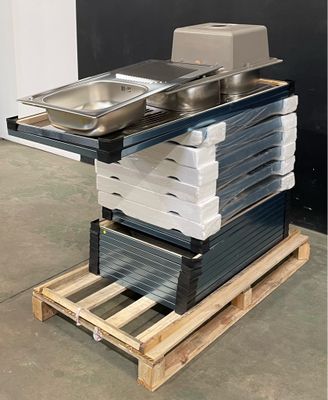 Plusieurs plateaux de nourriture sont empilés sur une palette devant un mur noir