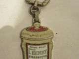 une photo d'un porte-clés sur lequel figure une bouteille de bière
