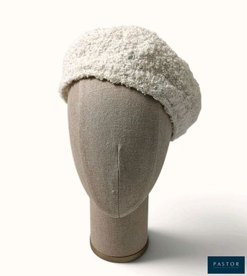 un chapeau blanc posé sur la tête d'un mannequin, sur fond blanc