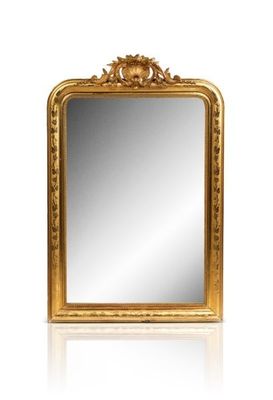 a gold framed mirror sitting on top of a white surface