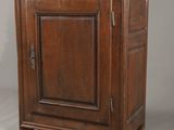 une vieille armoire en bois avec une porte et un tiroir au-dessus