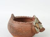 a small clay pot with a flower on it