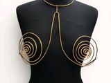 a black mannequin torso with gold spirals on it
