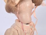 a doll that is wearing a pink dress and a pink hat