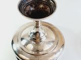 a silver vase that is sitting on a table