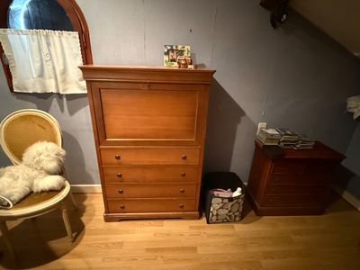 a dresser and a chair in a small room