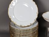 a stack of plates and bowls with gold rims