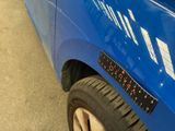 a close up of a blue car with a ruler on the side