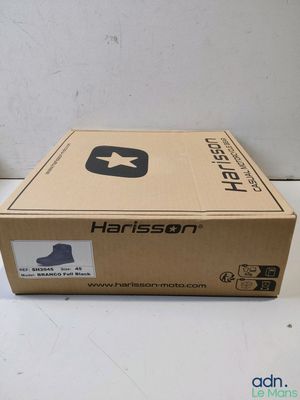 un gros plan sur une boîte posée sur une table, avec une paire de chaussures