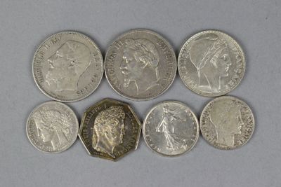 six different british coins are arranged in a row on a white surface