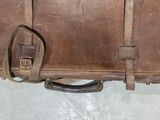 a brown suitcase sitting on the floor next to a wall